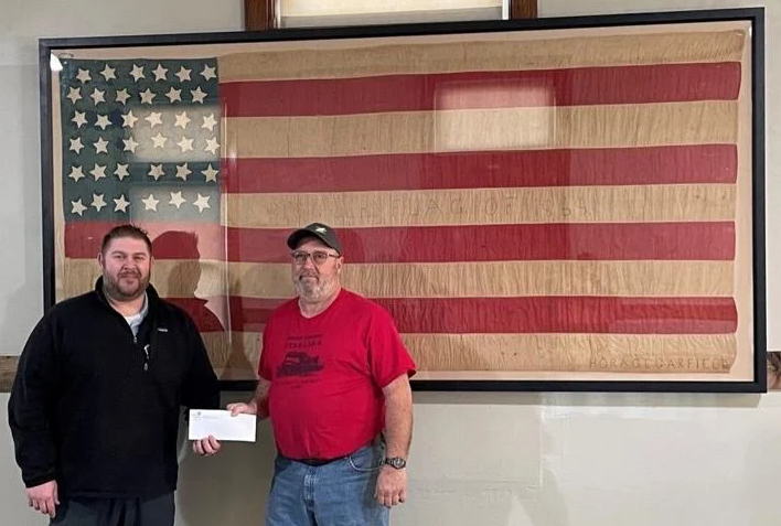 Bank of the Valley President Jason Lavicky (left) presented a check to the Butler County Historical Society for the preservation and framing of an 1868 American flag, believed to be the first of its type flown over Butler County.