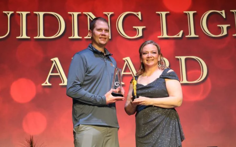 Gothenburg's Dayspring Bank Branch Manager Travis Anderson (left) accepts the Guiding Light Award from Rebecca Steward, president of the Gothenburg Chamber of Commerce.