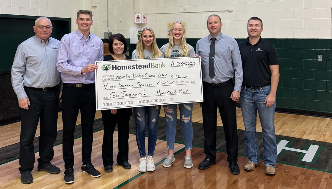 Homestead Bank employees presented a donor check to Howells-Dodge Consolidated Schools for a new video screen in the school gym.