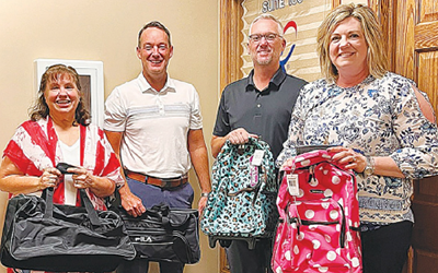 RuAnn Root from CASA (left) accepted the backpack donation from Wells Fargo staff Brian Stock, Troy Fry and Malinda Parr.